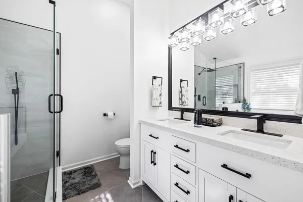 a bathroom with a double vanity sink mirror and toilet