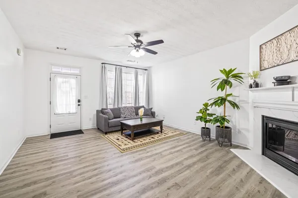 a living room with furniture a fireplace and a potted plant