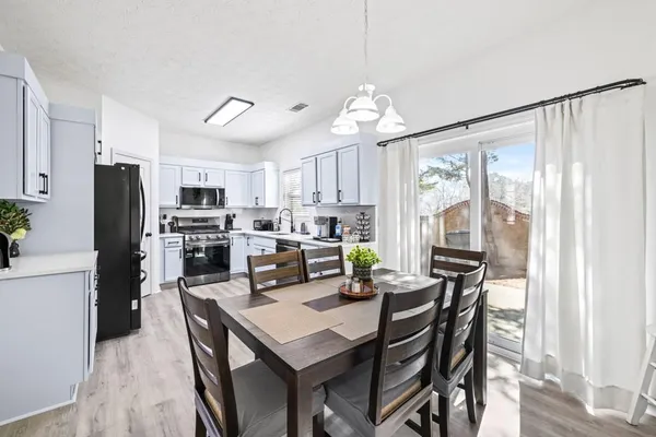 a kitchen with a table chairs refrigerator and microwave