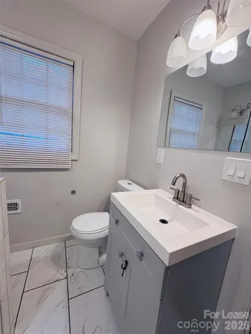 a bathroom with a sink a toilet and mirror