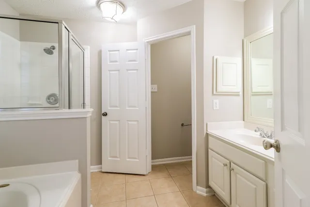 a bathroom with a tub sink and mirror