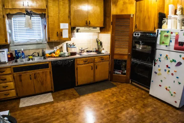 a kitchen with granite countertop a sink stove and cabinets