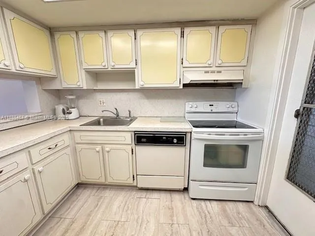 a kitchen with a refrigerator sink and cabinets