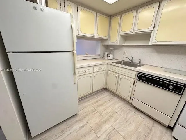 a kitchen with granite countertop white cabinets and white appliances
