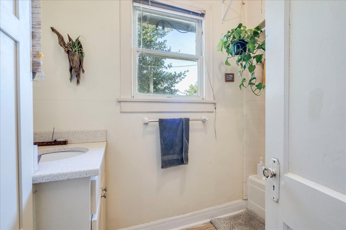 1103 West 22nd Street, Unit B Austin, TX 78705 - Photo 11 of 17 a bathroom with a granite countertop sink and a window