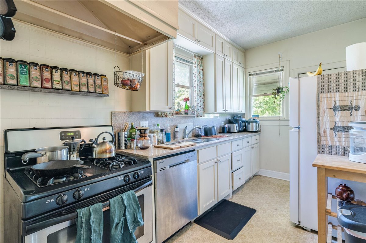 1103 West 22nd Street, Unit B Austin, TX 78705 - Photo 5 of 17 a kitchen with stainless steel appliances granite countertop a stove and a sink