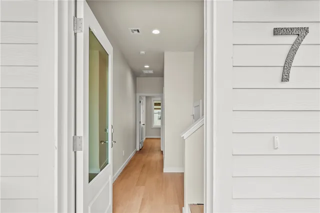 a view of a hallway with wooden floor and staircase