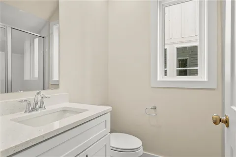 a bathroom with a granite countertop sink toilet a mirror and a tub