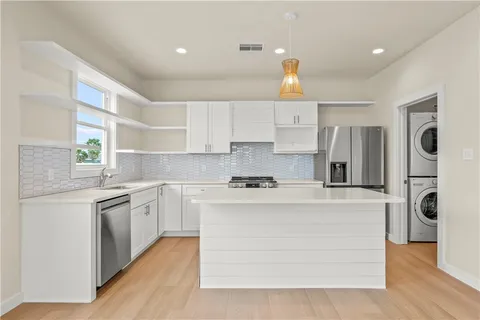 a kitchen with stainless steel appliances granite countertop a stove top oven a refrigerator a sink and dishwasher