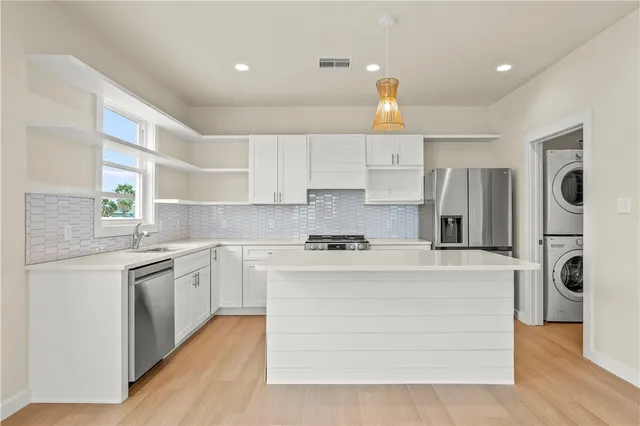 a kitchen with stainless steel appliances granite countertop a stove top oven a refrigerator a sink and dishwasher