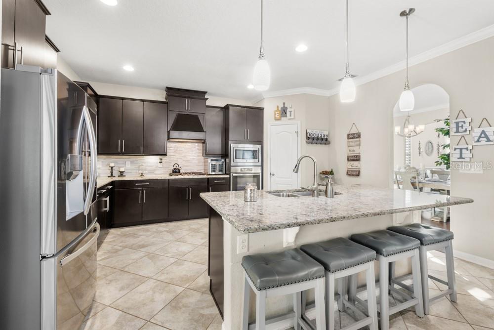 706 Fringe Tree Court Deland, FL 32724 - Photo 13 of 70 a kitchen with kitchen island granite countertop a sink cabinets and stainless steel appliances