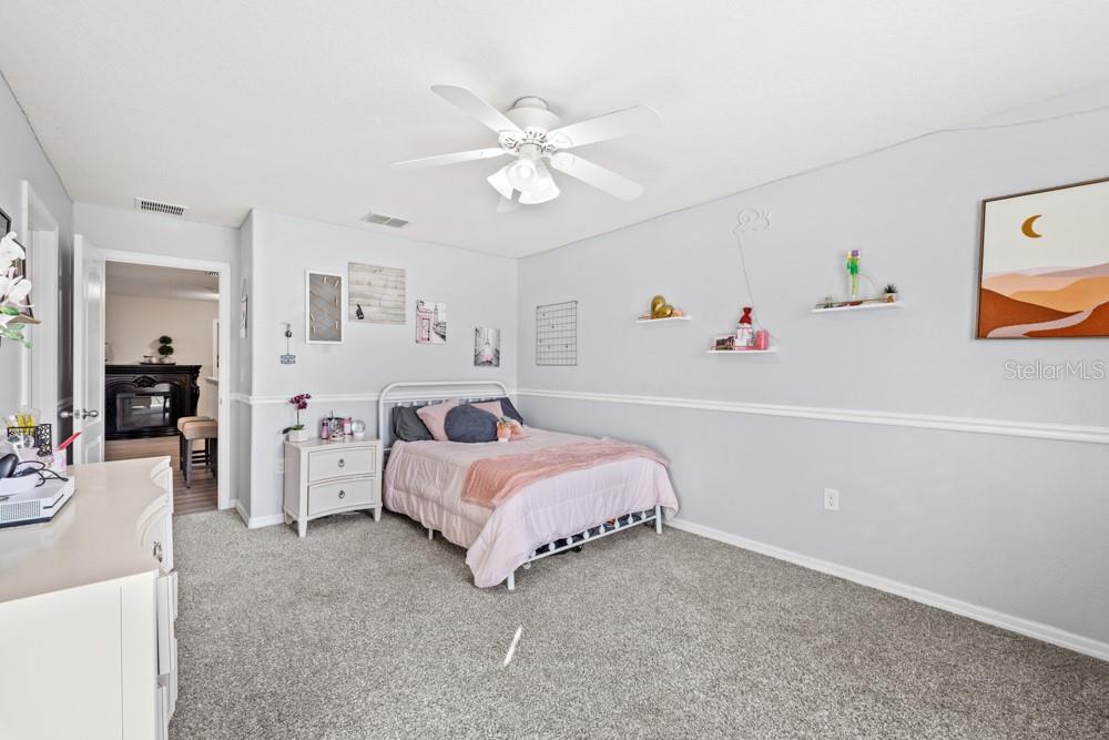 706 Fringe Tree Court Deland, FL 32724 - Photo 31 of 70 a spacious bedroom with a bed and a chandelier
