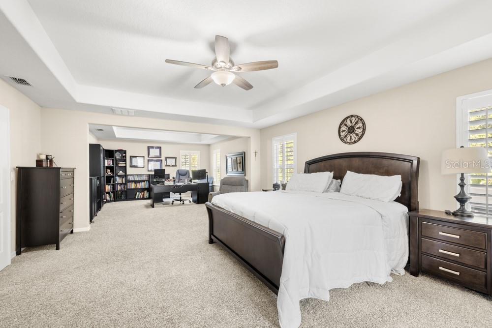 706 Fringe Tree Court Deland, FL 32724 - Photo 45 of 70 a spacious bedroom with a bed chandelier and a large window