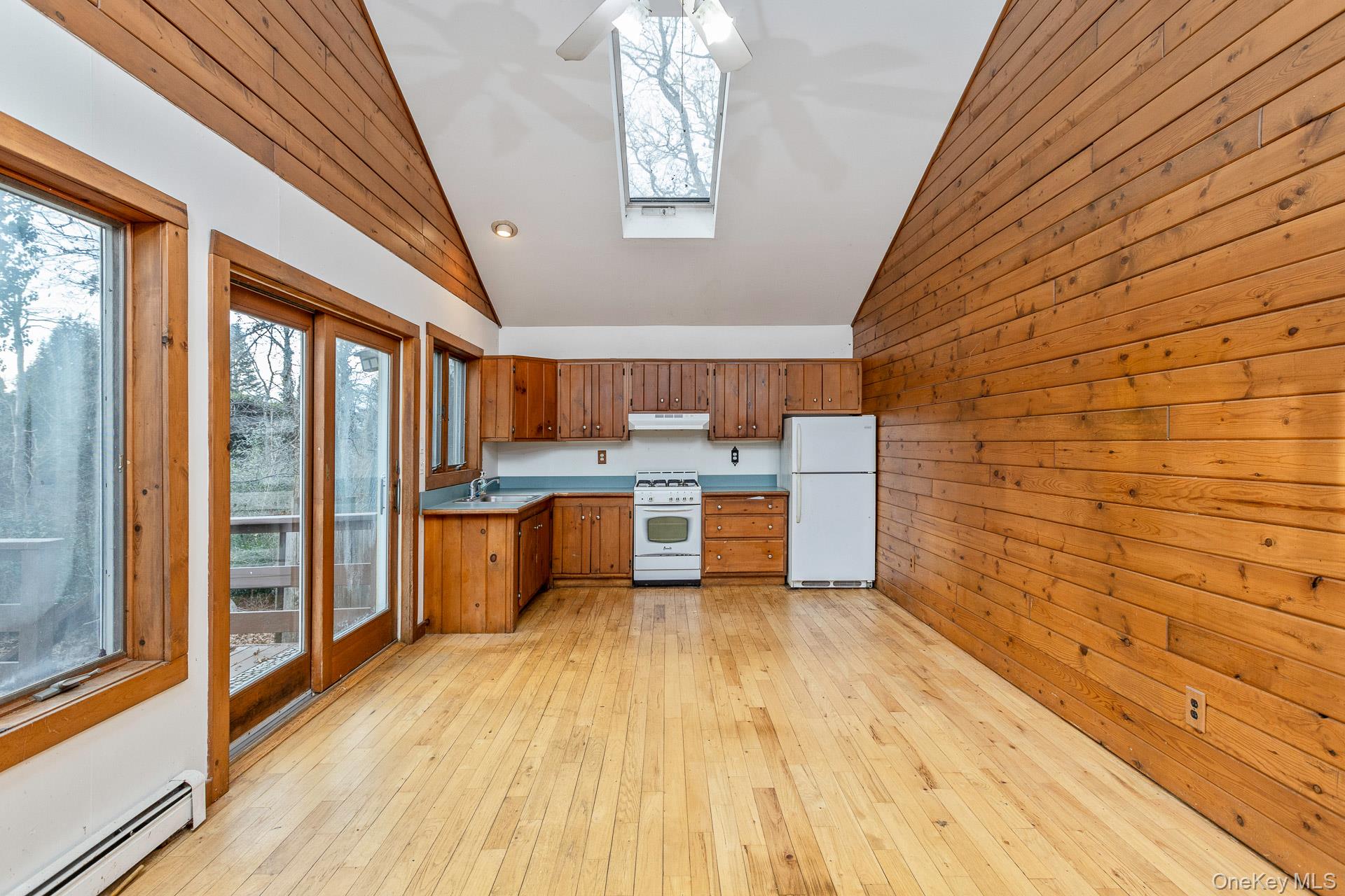 62 Birch Hill Road Mount Sinai, NY 11766 - Photo 8 of 36 a large kitchen with stainless steel appliances wooden floor and large windows