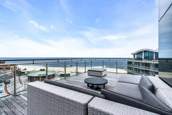 a roof deck with couches and potted plants with sky view