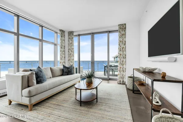 a living room with furniture a flat screen tv and a floor to ceiling window