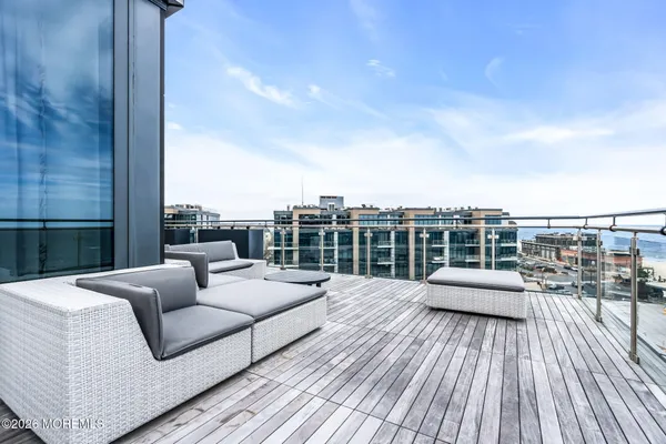 a view of roof deck with couches and wooden floor