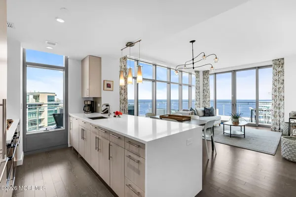 a large kitchen with kitchen island a large window a sink and living room view