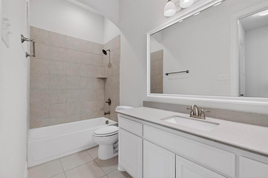 805 Rustic Trail Midlothian, TX 76065 - Photo 15 of 40 a bathroom with a granite countertop toilet a sink and a bathtub