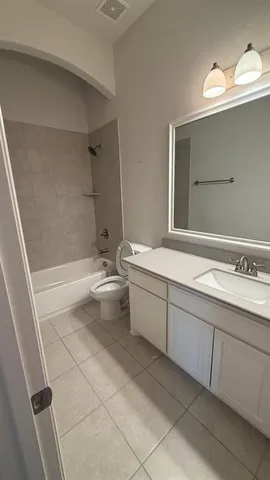 a bathroom with a bathtub sink mirror and toilet