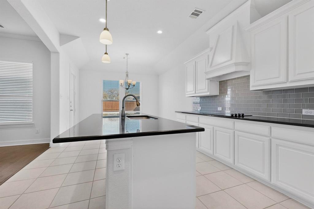 805 Rustic Trail Midlothian, TX 76065 - Photo 10 of 40 a kitchen with kitchen island granite countertop a sink and white cabinets