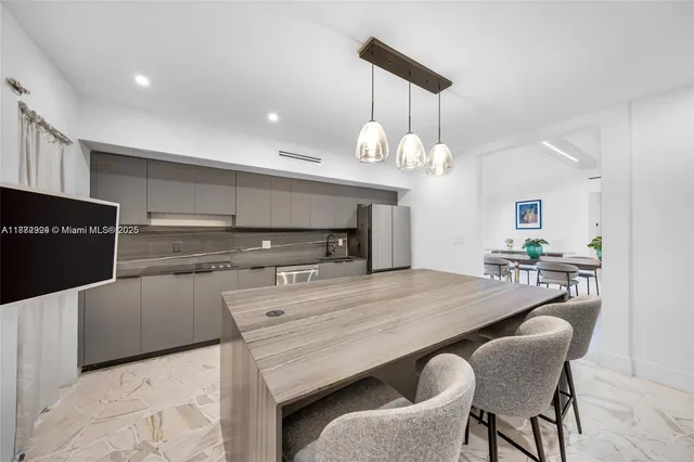 a kitchen view with kitchen island stainless steel appliances a sink cabinets and wooden floor