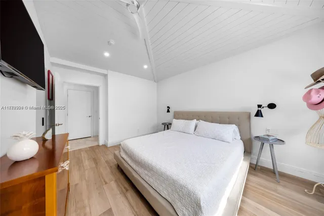 a bedroom with a bed and a flat screen tv