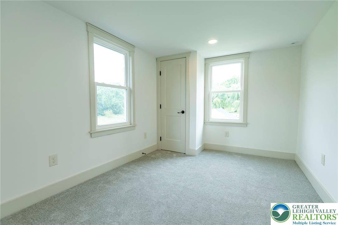 72 Allegheny Road Mount Bethel, PA 18343 - Photo 32 of 72 A well-lit room with soft gray carpet and two sun-drenched windows provides a serene retreat.