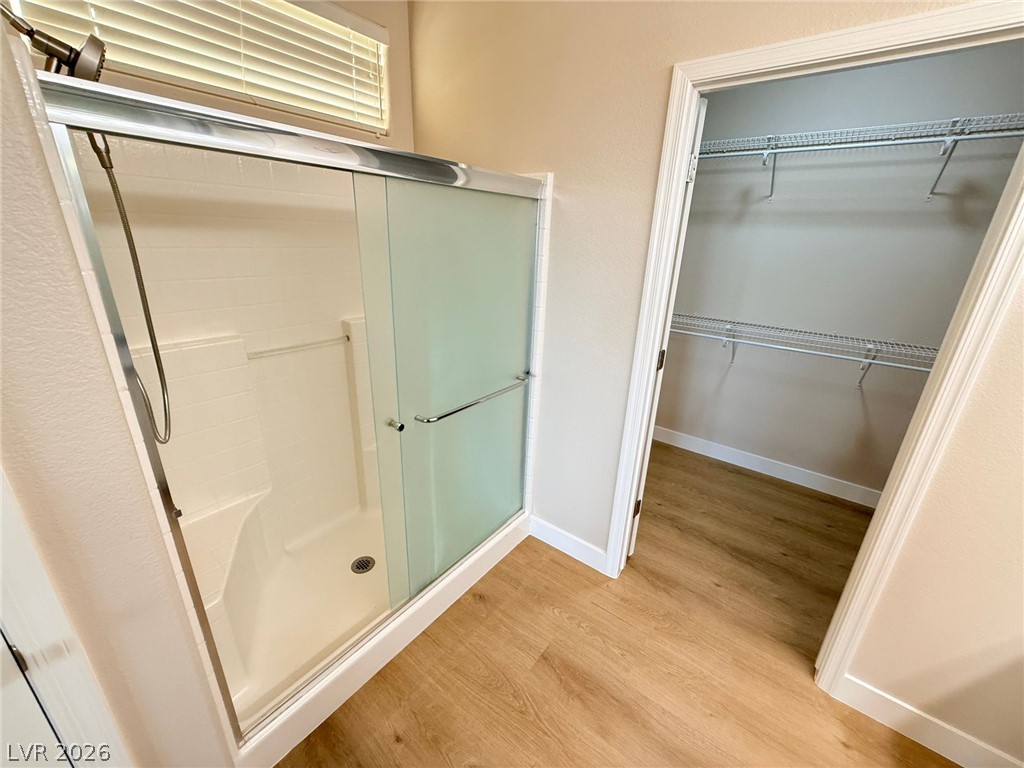 3036 Fort Stanwix Road Henderson, NV 89052 - Photo 15 of 18 Warm wood flooring flows from the shower area directly into a spacious walk-in closet.