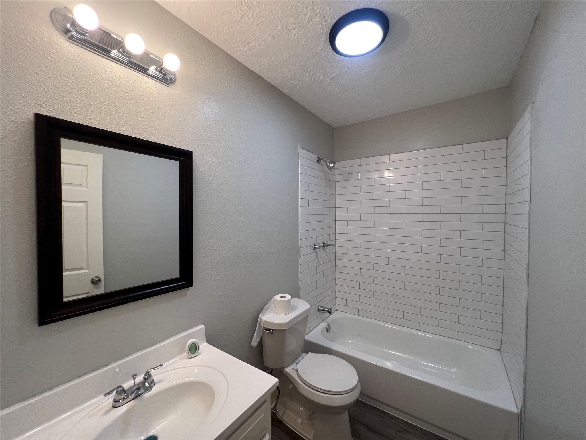 2412 Stuart Street Houston, TX 77004 - Photo 16 of 32 a bathroom with a toilet a sink a mirror and shower
