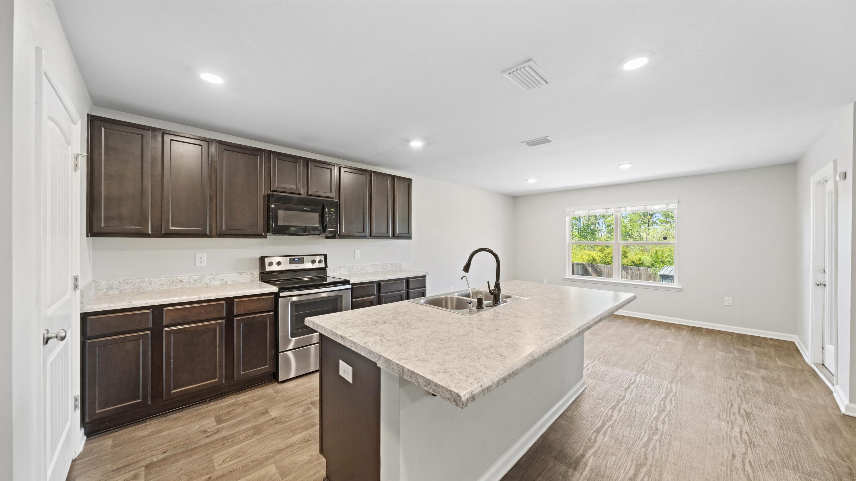 3927 Alva Thomas Road Panama City, FL 32404 - Photo 9 of 46 a kitchen with a sink cabinets and wooden floor