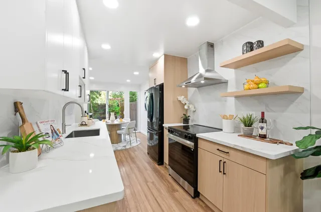 a kitchen with granite countertop a white stove top oven and cabinets