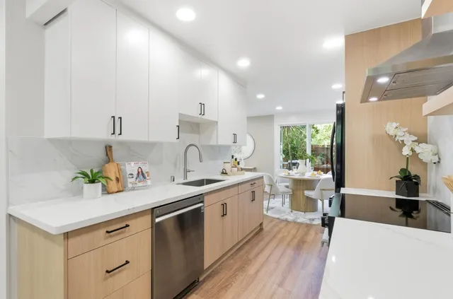 a view of a dining room with furniture a kitchen and chandelier