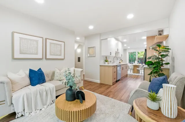 a kitchen with granite countertop a sink a stove refrigerator and cabinets