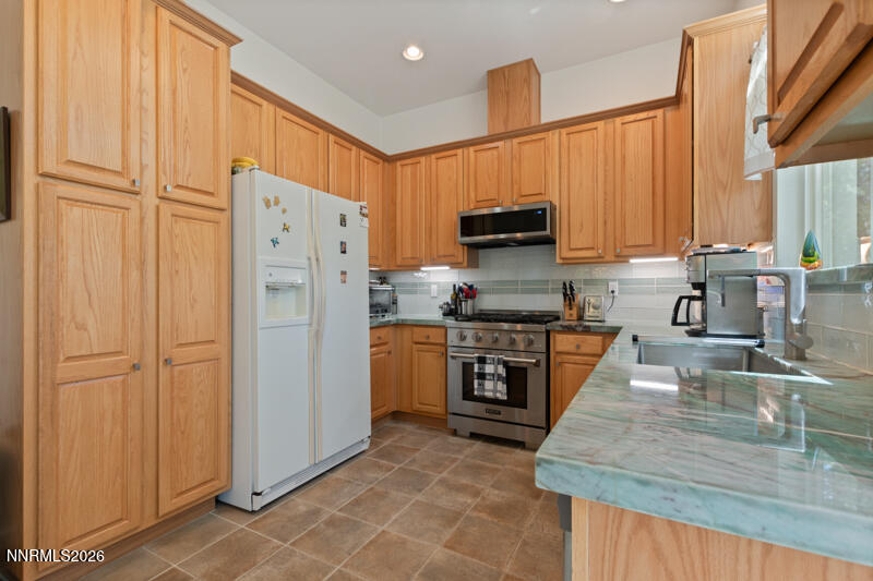 403 Sierra Leaf Circle Reno, NV 89511 - Photo 10 of 25 a kitchen with stainless steel appliances granite countertop a refrigerator stove and sink