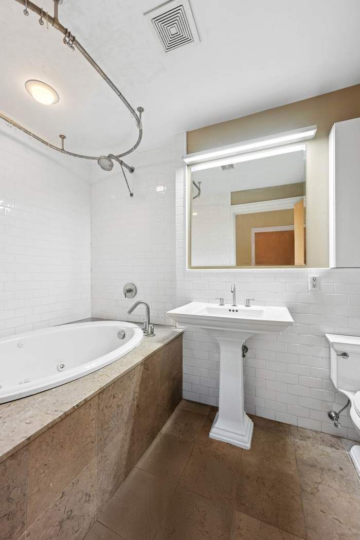 57 Front Street, Unit 604 Brooklyn, NY 11201 - Photo 6 of 14 a bathroom with a bathtub a sink and mirror