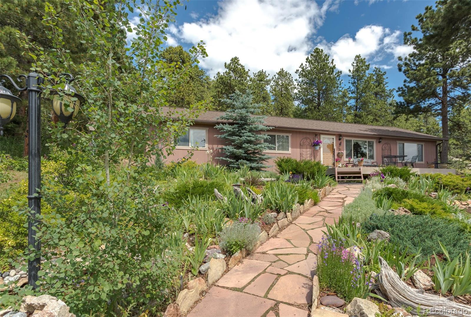 32147 Sylvan Road Golden, CO 80403 - Photo 1 of 27 a view of a house with a yard and potted plants