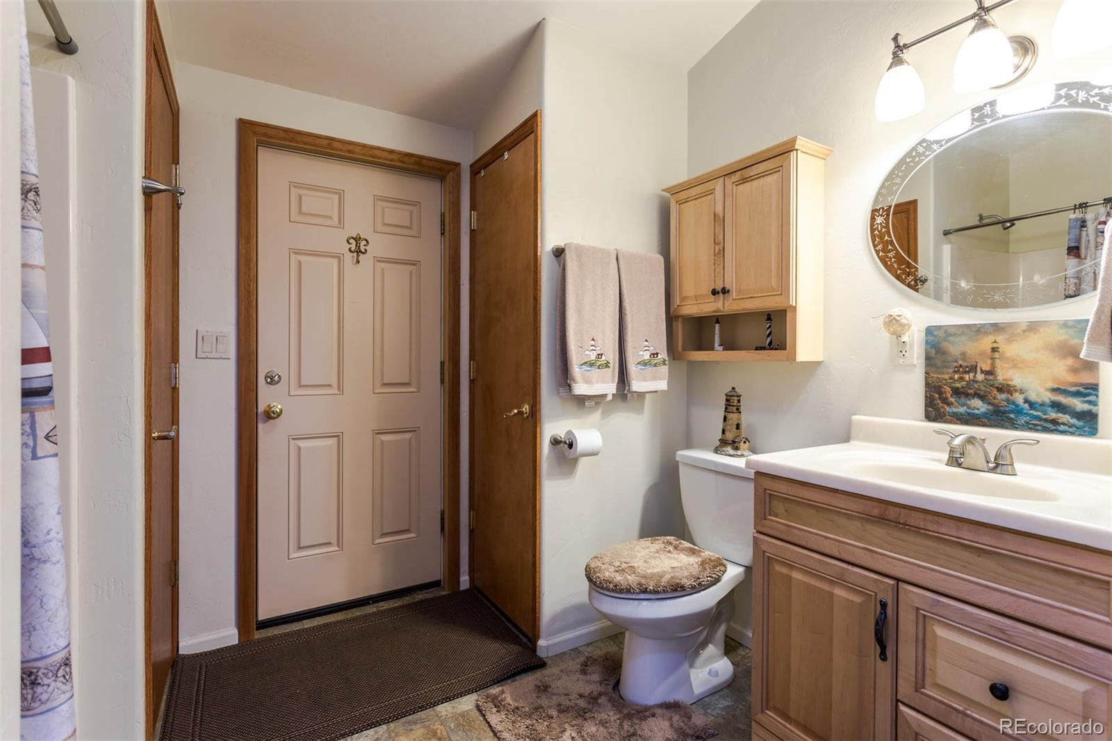 32147 Sylvan Road Golden, CO 80403 - Photo 21 of 27 a bathroom with a toilet sink and mirror