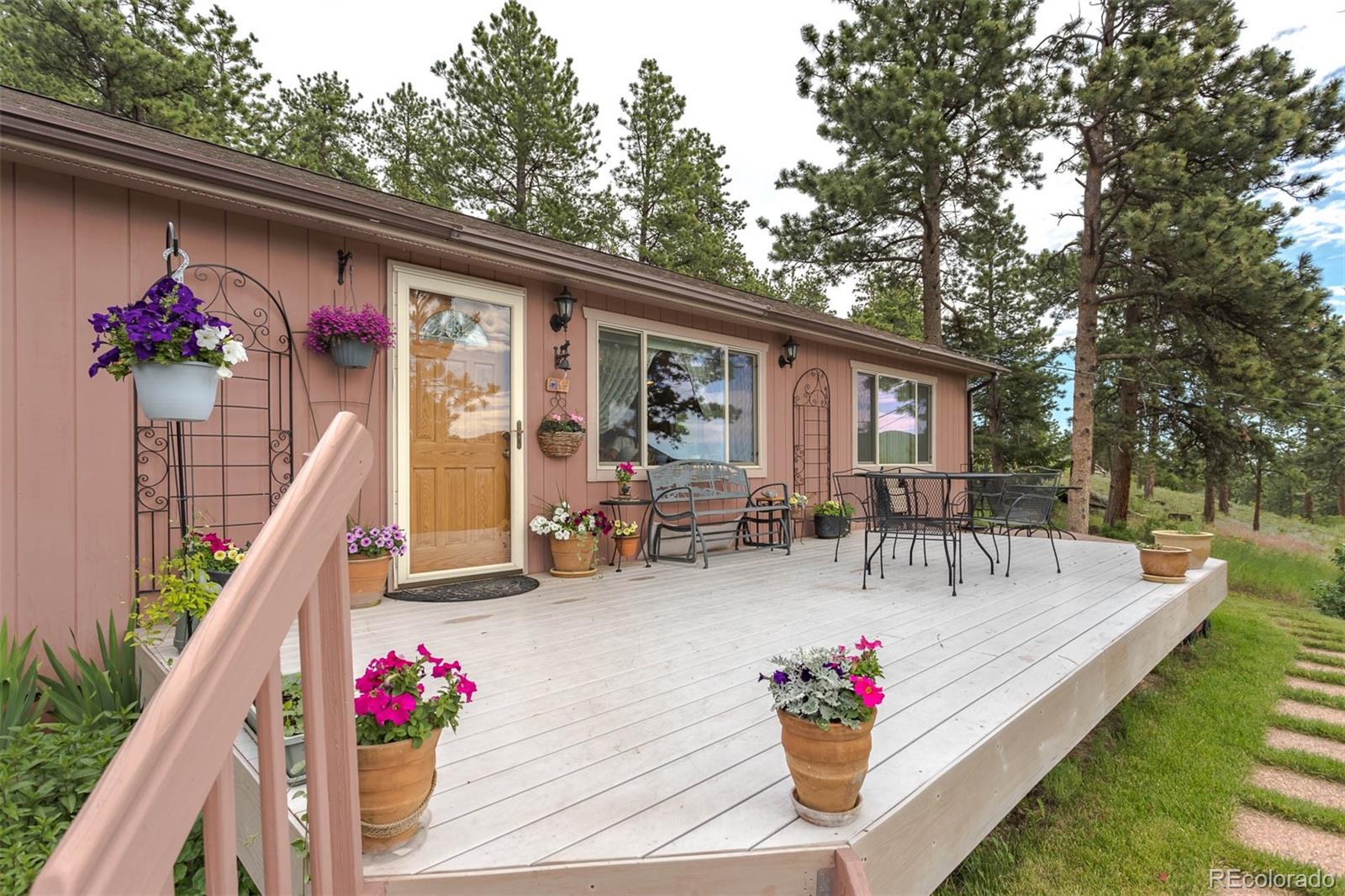 32147 Sylvan Road Golden, CO 80403 - Photo 4 of 27 a view of a patio with couches table and chairs and potted plants