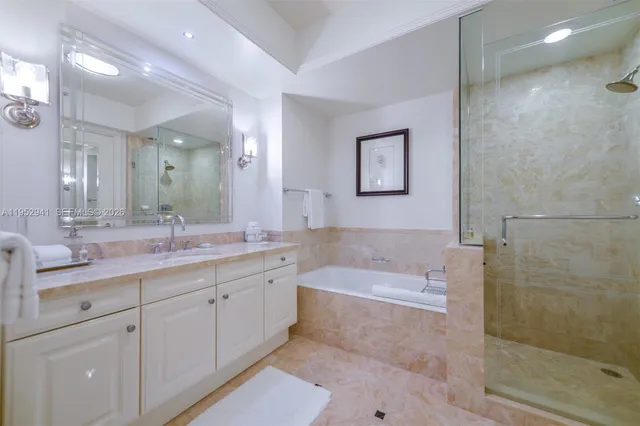 a bathroom with a tub a sink shower and mirror