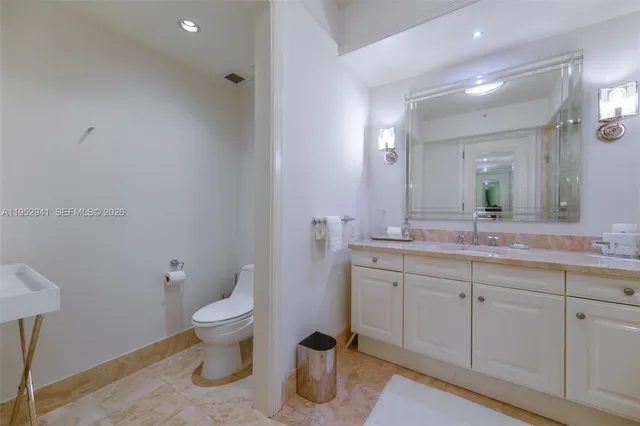 a spacious bathroom with a toilet sink and mirror