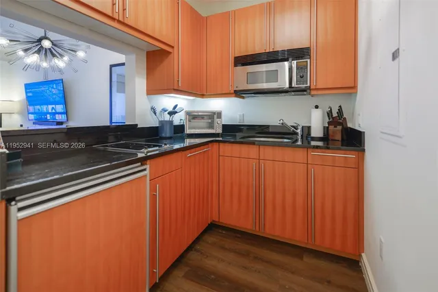 a kitchen with granite countertop wooden cabinets and a stove top oven