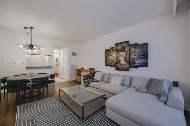a living room with furniture a piano and a bookshelf