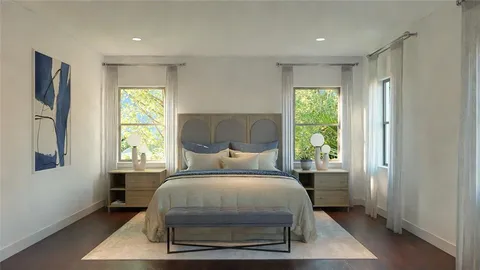 a bedroom with a bed a table and windows