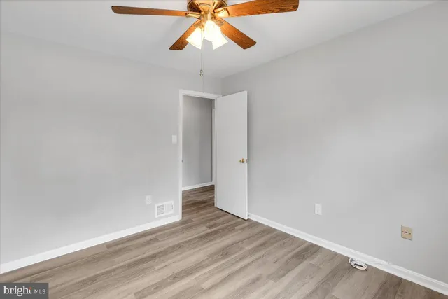 a view of a room with wooden floor and ceiling fan