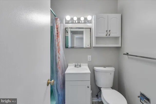 a bathroom with a toilet sink and mirror