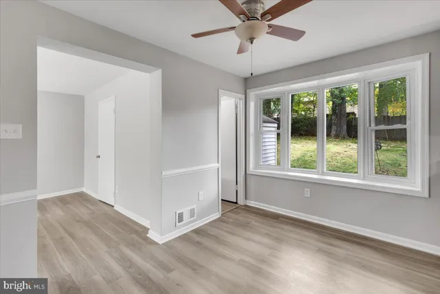 an empty room with fan and windows