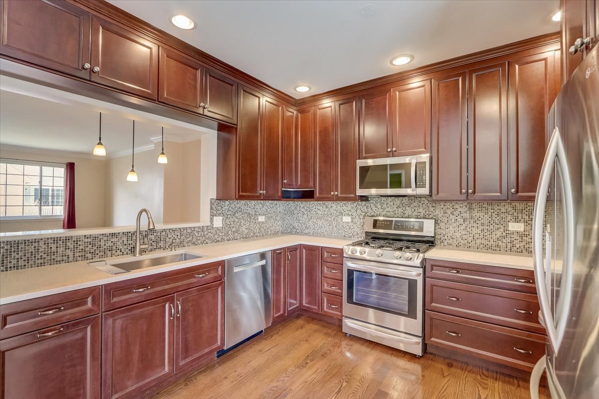 3372 Ravinia Circle Aurora, IL 60504 - Photo 12 of 39 a kitchen with stainless steel appliances granite countertop wooden cabinets and a sink