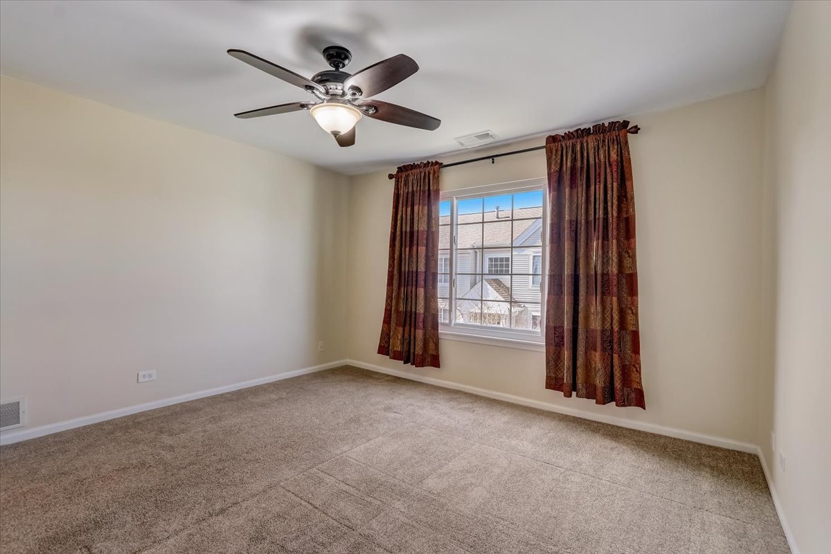 3372 Ravinia Circle Aurora, IL 60504 - Photo 19 of 39 a view of an empty room with a ceiling fan