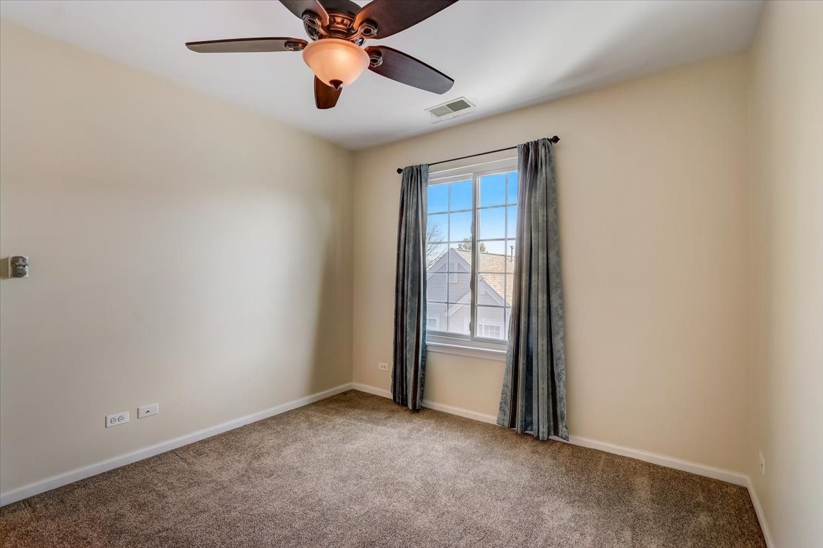 3372 Ravinia Circle Aurora, IL 60504 - Photo 24 of 39 an empty room with chandelier fan and windows